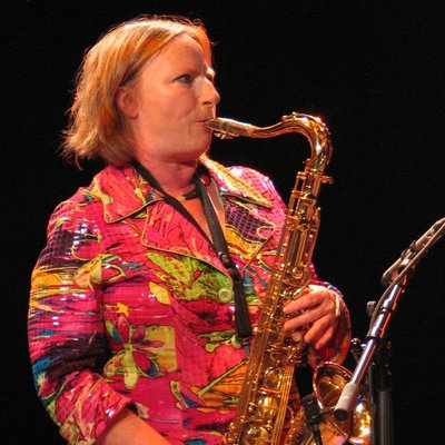 Jo in bright clothes, playing saxophone