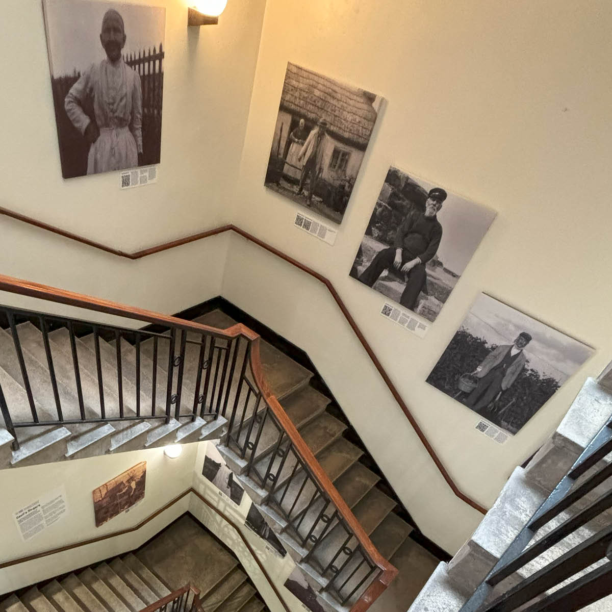 winding staircase with square canvases on the walls