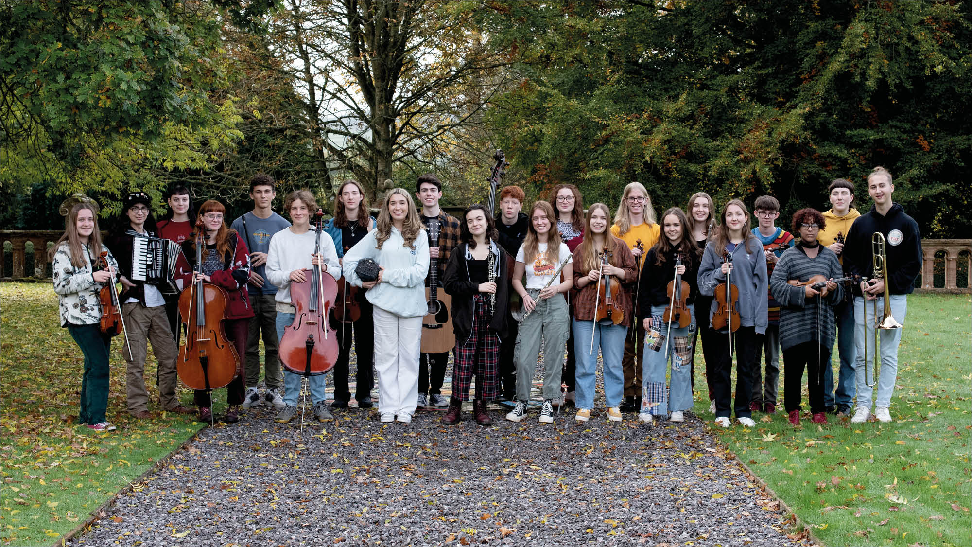 Ensemble of young people holding instruments and looking at camera