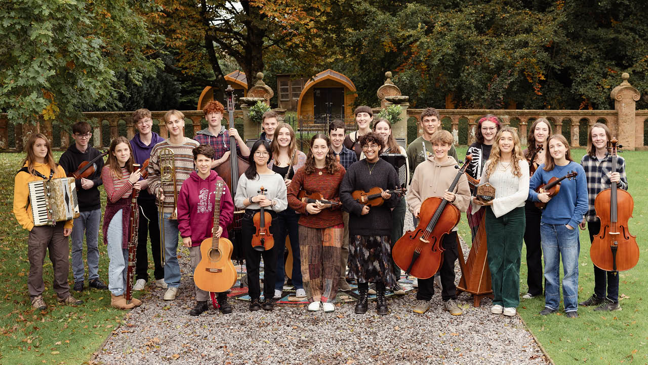 Ensemble of young people holding instruments and looking at camera