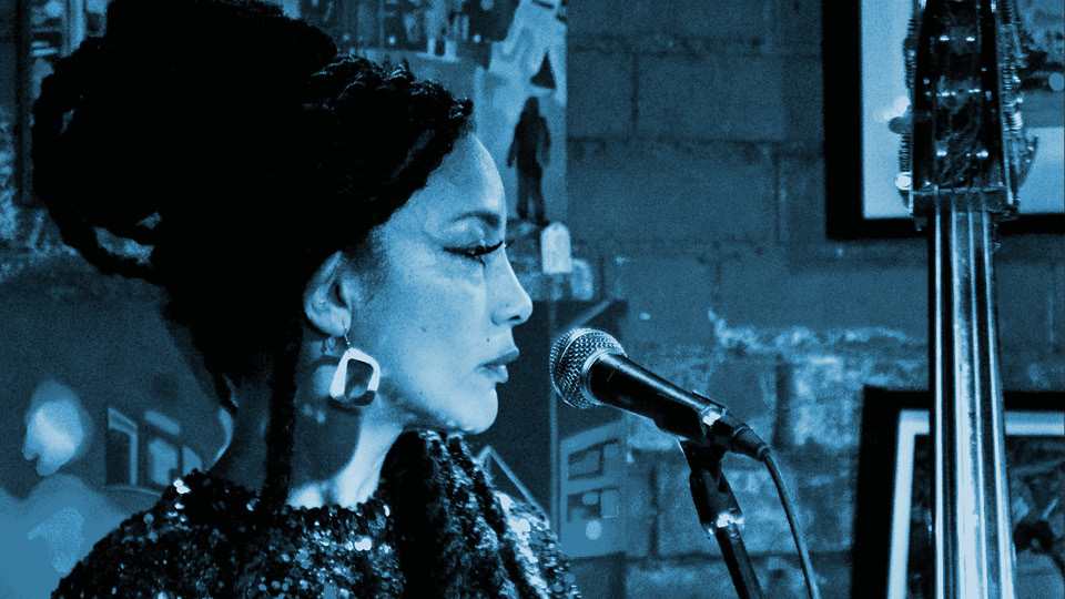Angeline in profile, at microphone with double bass in the background
