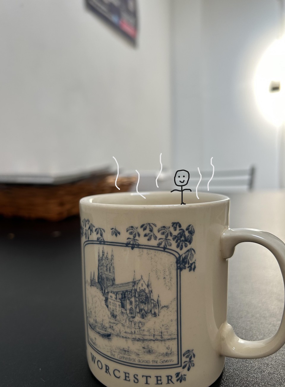A stick figure sitting inside a mug of steaming tea