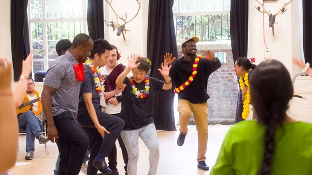 A group of children and adults dancing.