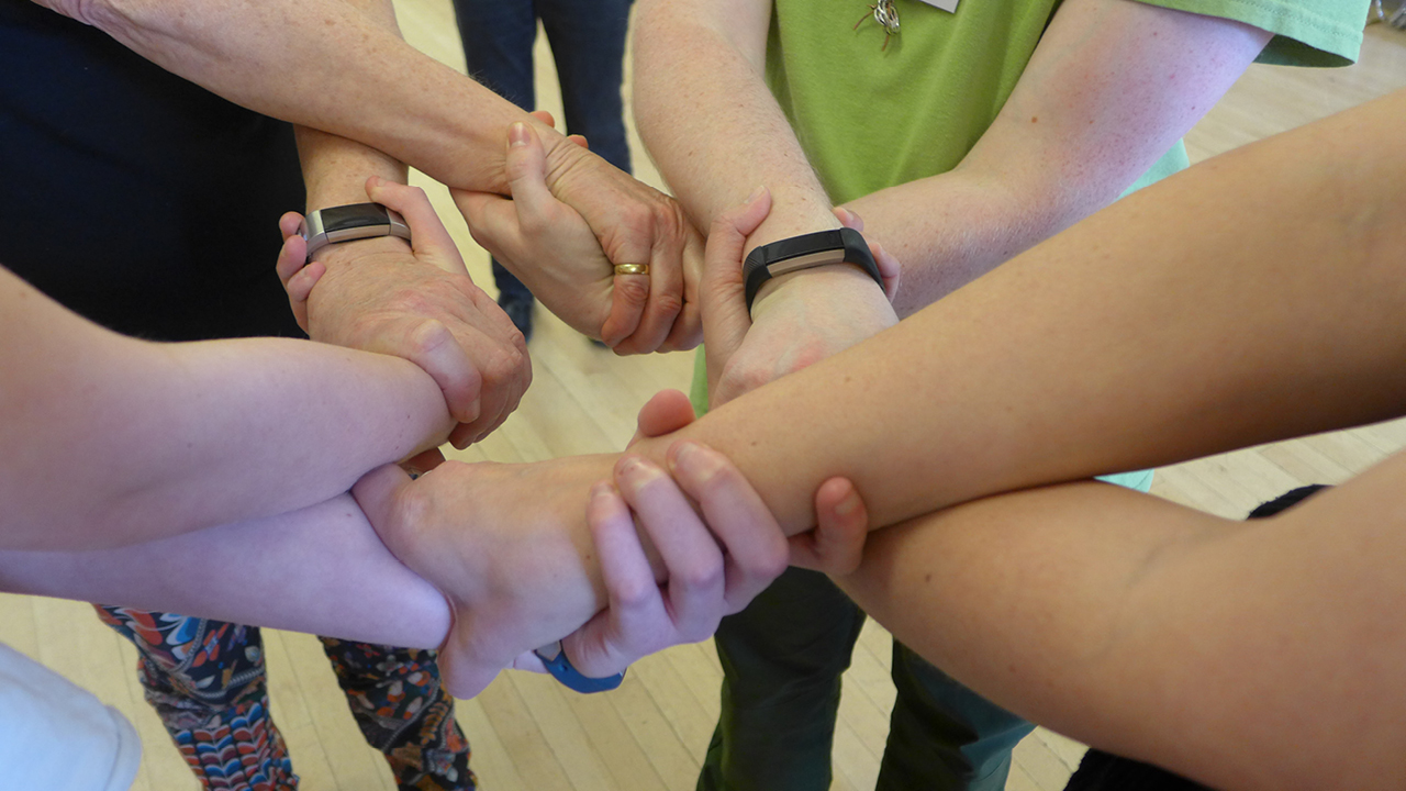 a group of dancers' interlocked hands