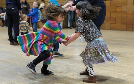 Two young children dancing together.