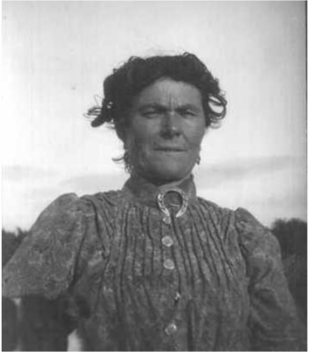 A black-and-white photo of a woman with a horseshoe collar.